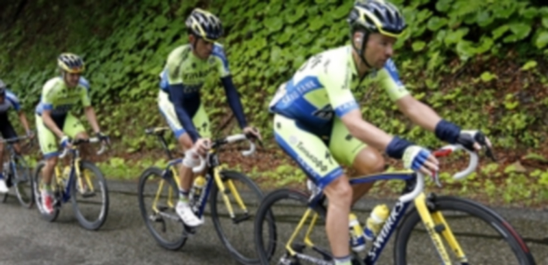 Alberto Contador con la pierna vendada tras su caída el pasado lunes es ayudado por sus compañeros del Saxo-Tinkoff a regresar al grupo de cabeza. / Efe