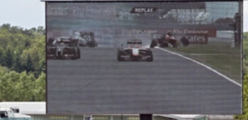 El accidente del piloto de Ferrari visto en una de las pantallas del circuito. / Efe