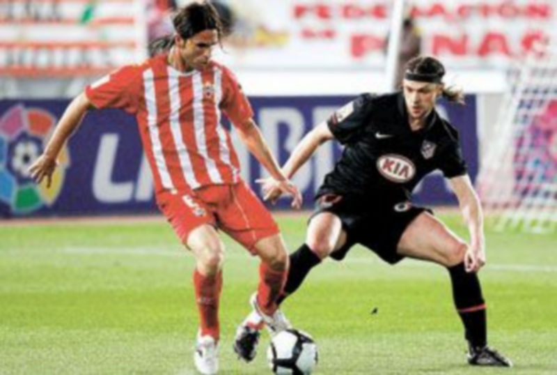 El defensa del Almería Domingo Cisma (i) controla el balón ante el checo Tomas Ujfalusi. /EFE