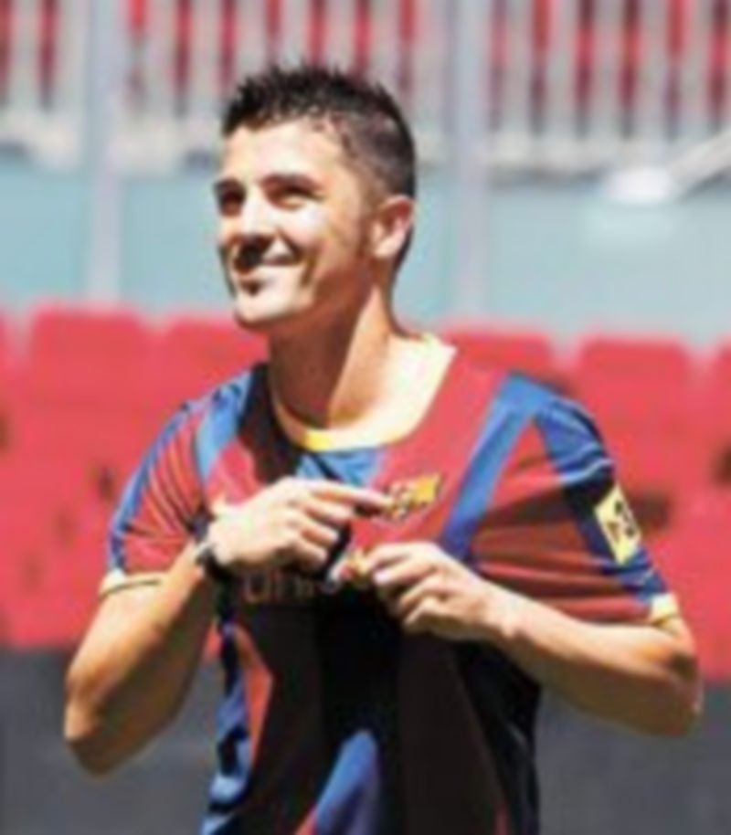 El atacante asturiano muestra el escudo de la camiseta durante su comparecencia ante los aficionados que acudieron al Camp Nou a recibirle. / Reuters