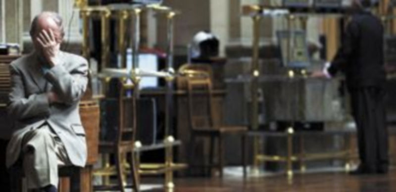 Un ciudadano no puede evitar llevarse una mano a la cara cuando la prima de riesgo superó los 500 puntos básicos al inicio de la jornada de ayer. / Reuters