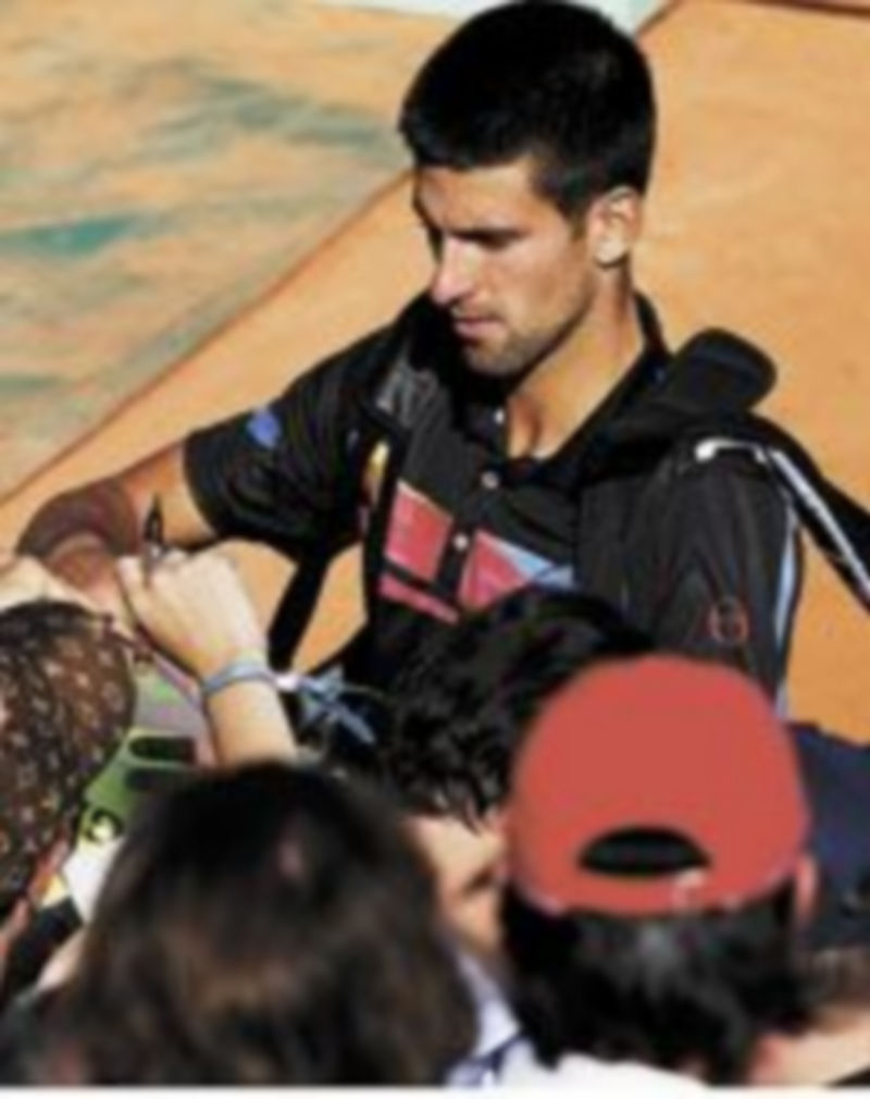 Djokovic firma autógrafos al concluir su duelo. / Reuters