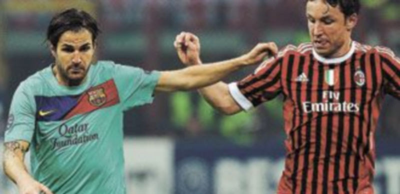 Cesc disputa el esférico con el holandés Van Bommel durante el encuentro ante el Milan. /Efe