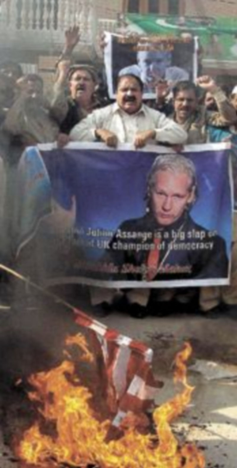 Un grupo de paquistaníes quema una bandera de EEUU durante una protesta contra el arresto de Julian Assange. / EFE