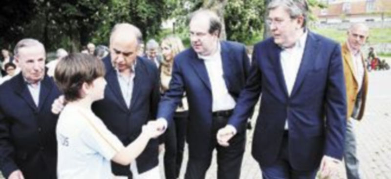 Juan Vicente Herrera saluda a un niño acompañado por Miguel Ángel García Nieto y José Manuel Fernández Santiago (d). /Ical