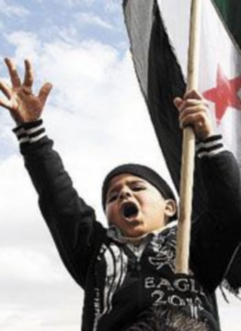 Un niño con una bandera siria.