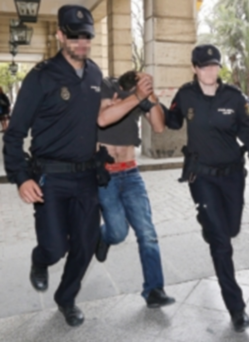 Dos agentes de la Policía Nacional acompañan a uno de los dos arrestados por el fallecimiento del menor. / Efe