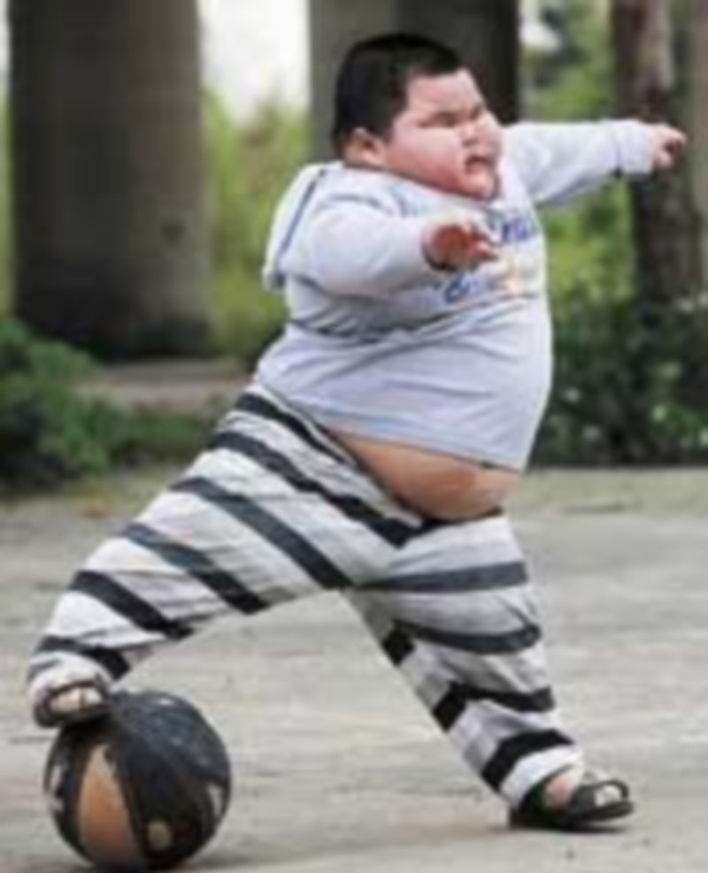 Un niño obeso juega con dificultad a la pelota. / Reuters