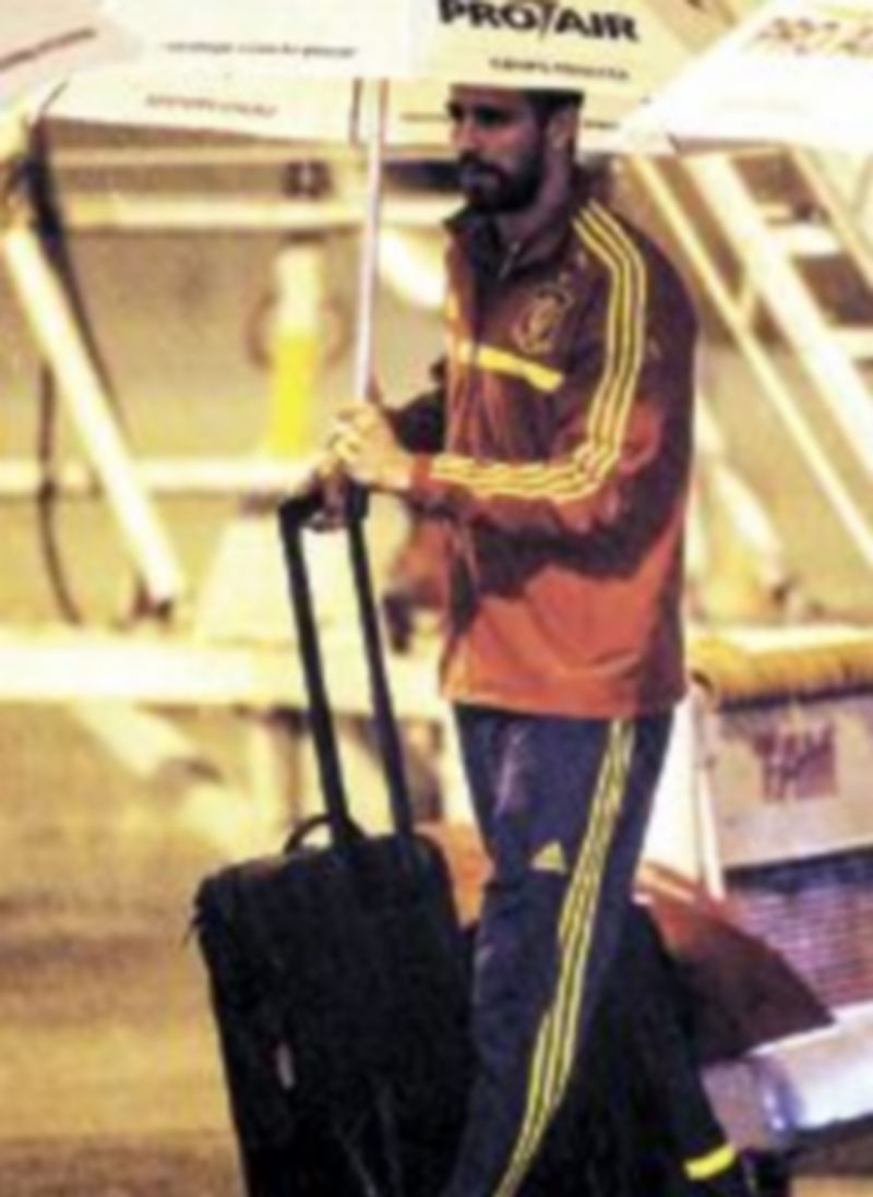 Una intensa lluvia obligó a los jugadores a bajar con paraguas del avión. / Efe