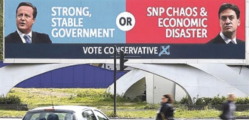 Un cartel electoral muestra al líder conservador David Cameron y al representante de los laboristas