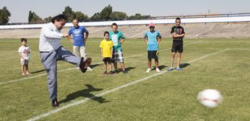 El alcalde Pedro Arahuetes chuta el balón en el nuevo campo de fútbol 7 de Madrona. / Lara Mazagatos