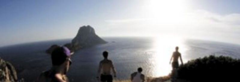 Los turistas se reúnen para ver la puesta de sol en los acantilados de Es Vedra