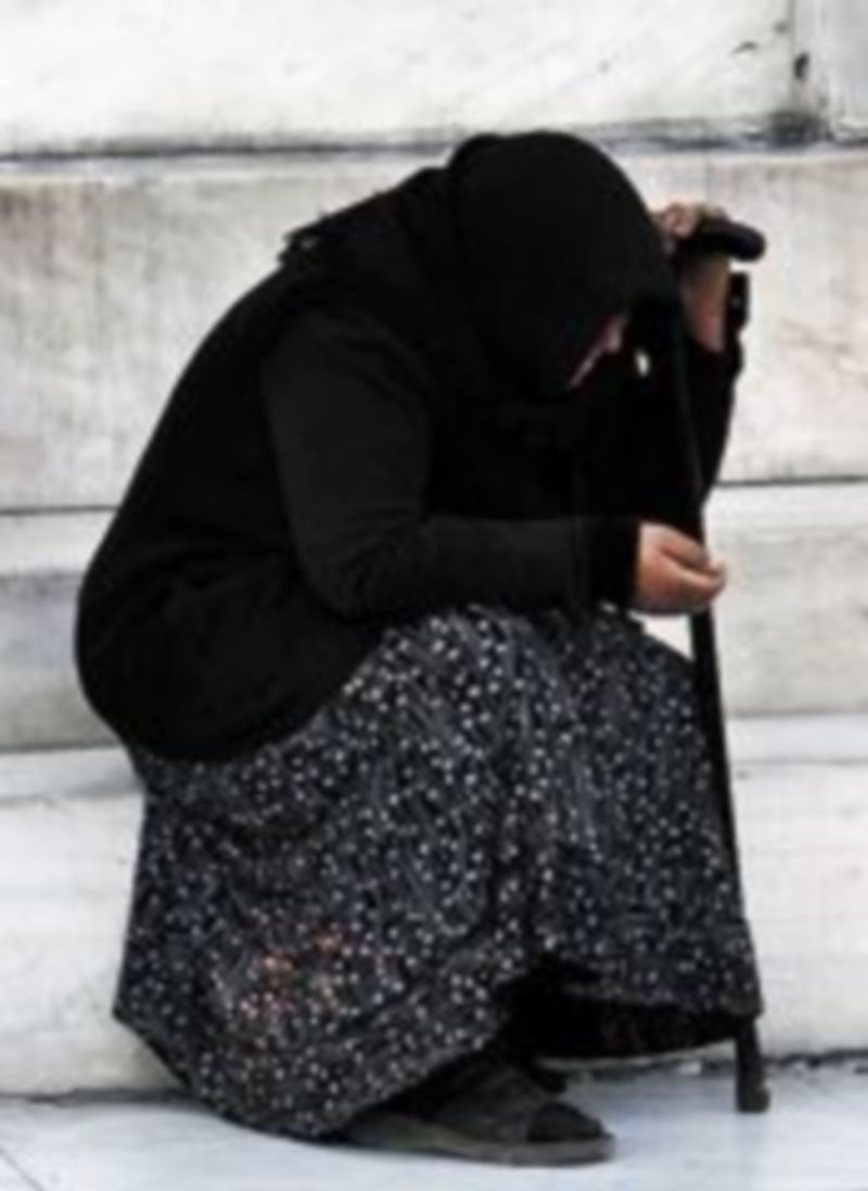 Una mendiga descansa en la escalinata del Banco de Grecia. / Reuters.