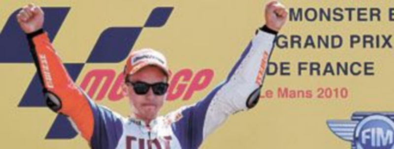 Jorge Lorenzo levanta los brazos en señal de victoria en el primer escalón del podio. / Reuters
