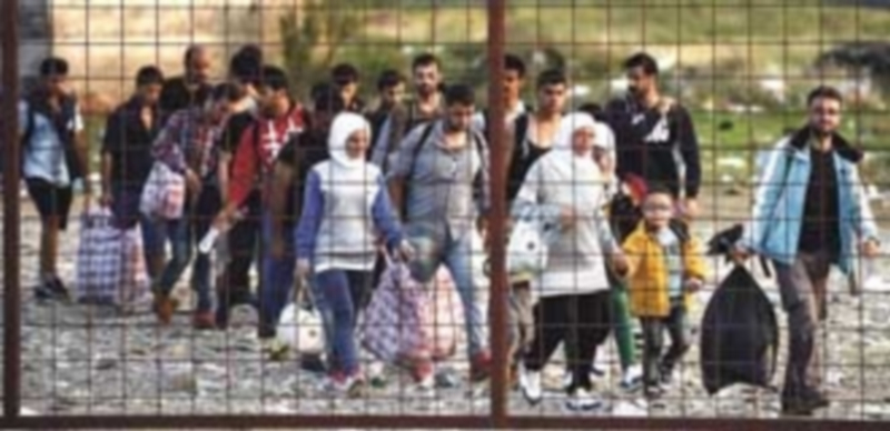 Varios refugiados llegan a un campo de registro para abordar un tren que les lleve hacia la frontera con Serbia. / EFE