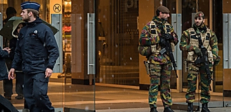 Militares belgas custodian junto a la Policía un centro comercial en Bruselas tras el incremento del nivel de alerta. / Efe