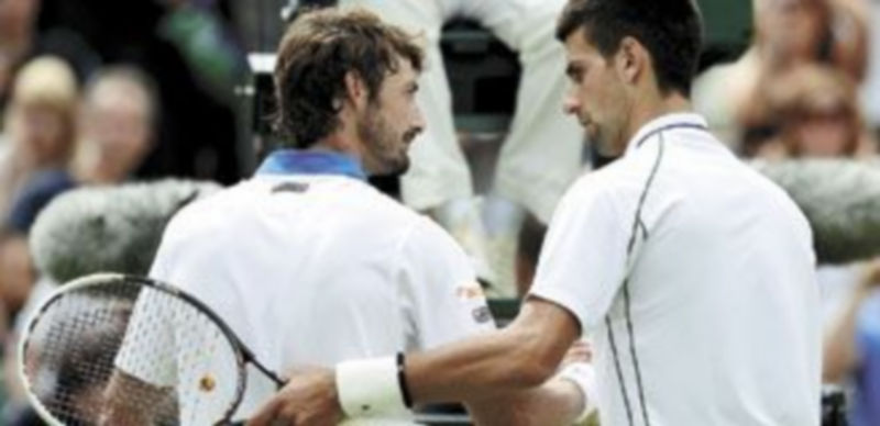 Ferrero y Djokovic se saludan a la conclusión del partido en la pista central del All England Club. / Reuters