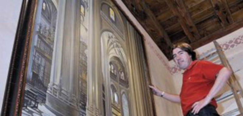 El pintor colocó ayer el cuadro en la recepción del Hotel Palacio San Facundo. / Kamarero