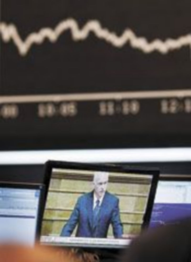 Un experto en Bolsa observa al primer ministro griego en una pantalla del parqué de Fránfort. / F. Rumpenhorst (EFE)