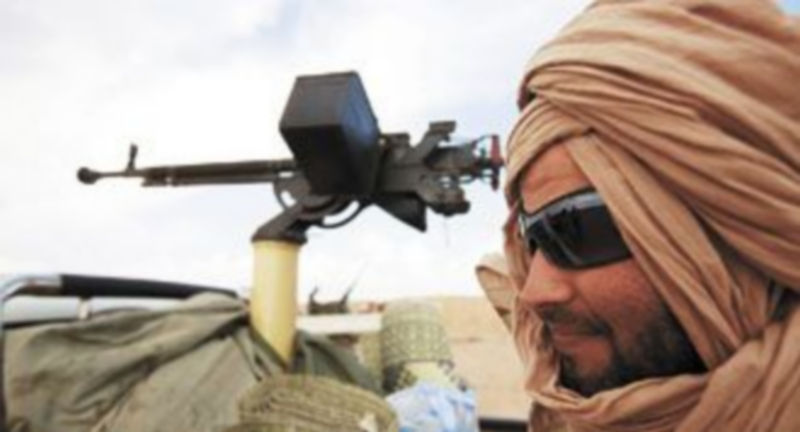 Un efectivo rebelde aguarda junto a un vehículo armado en uno de los puestos de control que los antigubernamentales han establecido en torno a Ajdabiyah. / Reuters