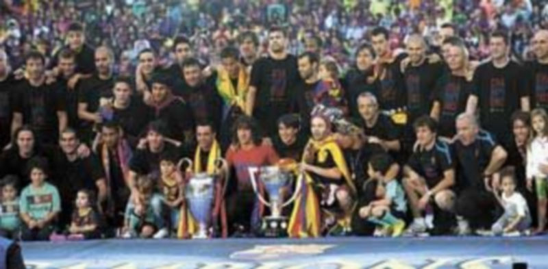 Los jugadores posan con los trofeos de la Champions y la Liga./ Efe