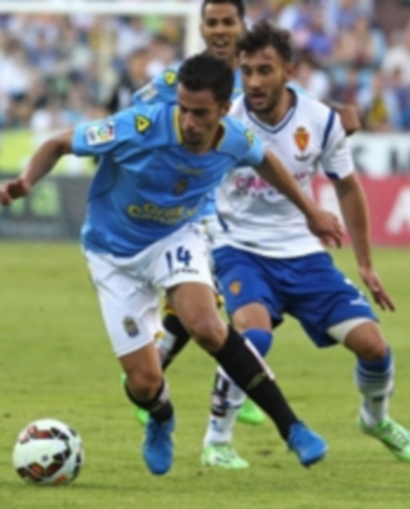 El centrocampista canario Hernán Santana (i) controla el balón ante el defensa Mario Abrante durante el partido de ida. / EFE