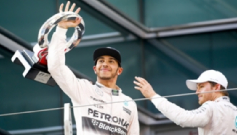 Lewis Hamilton sostiene el trofeo que le acredita como vencedor del Gran Premio de China 2015 ante la mirada de su compañero de escudería Nico Rosberg (der). / EFE