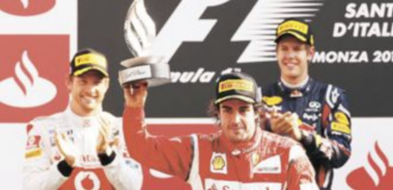 Fernando Alonso saluda desde el podio ante los aplausos de Jenson Button y Sebastian Vettel. / G. Sposito (Reuters)
