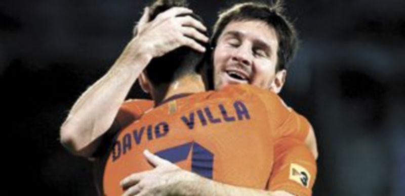Messi y Villa se abrazan después de que el argentino anotara su segundo gol. / Reuters
