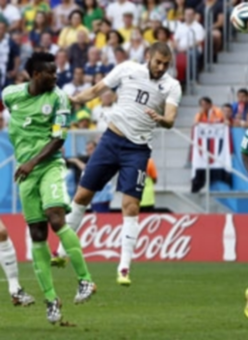 El delantero francés Karim Benzema remata de cabeza ante los jugadores nigerianos. / Efe