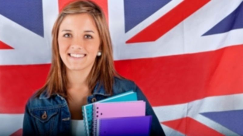 Una estudiante que recibió una beca Erasmus posa con sus cuadernos junto a la bandera británica. / Europa Press