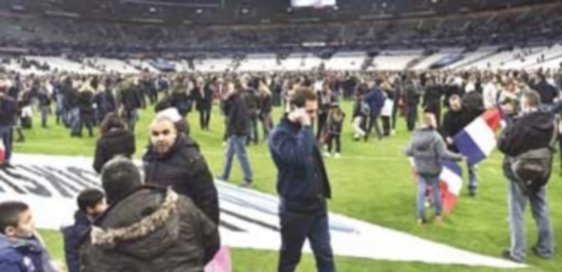 Los espectadores que asistían al encuentro amistoso de fútbol entre Francia y Alemania se concentraron en el césped del Stade de France tras las explosiones. / EFE