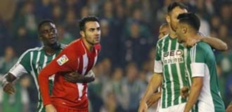 El bético N’Diaye sujeta a Iborra mientras discute con Petros durante el derbi de Sevilla que terminó con empate sin goles en el Benito Villamarín. / EFE