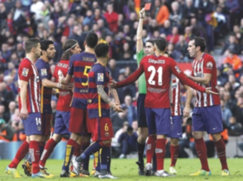 Undiano Mallenco muestra la tarjeta roja a Filipe Luis tras la entrada a Messi en el Camp Nou al borde del descanso. / EFE
