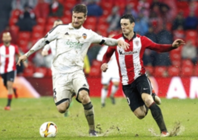 El central valencianista Mustafi (izq) pelea por la posesión del balón con Aduriz durante el partido de ida. / EFE