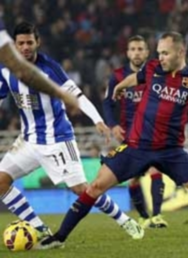 Iniesta intenta controlar el balón ante la presencia de Carlos Vela (izquierda) durante el partido de la temporada pasada. / EFE