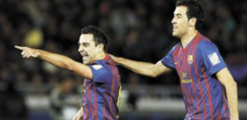 Xavi Hernández y Sergio Busquets celebran un gol del FC Barcelona. / Reuters