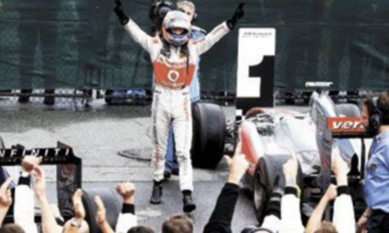 El piloto británico comparte su alegría en el parque de vehículos junto a los integrantes del equipo McLaren Mercedes. / CHRIS WATTIE (Reuters)