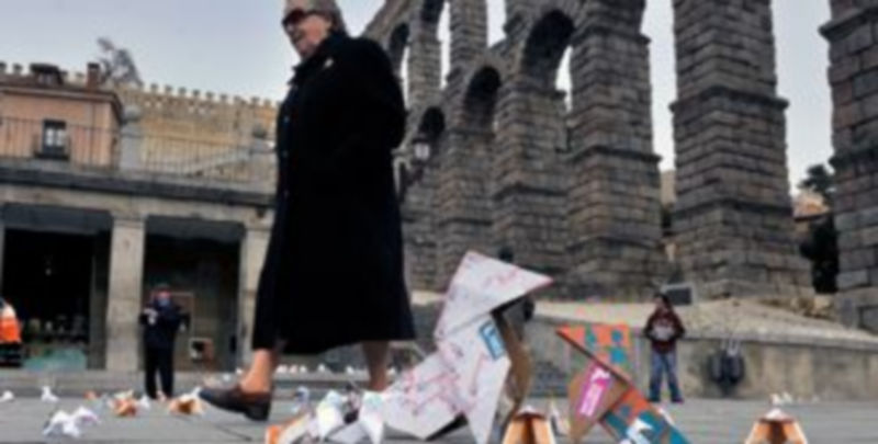 Origami publicitario 1 Una mujer pasea por el Azoguejo junto a las pajaritas diseminadas por el suelo junto al Acueducto.. / Kamarero