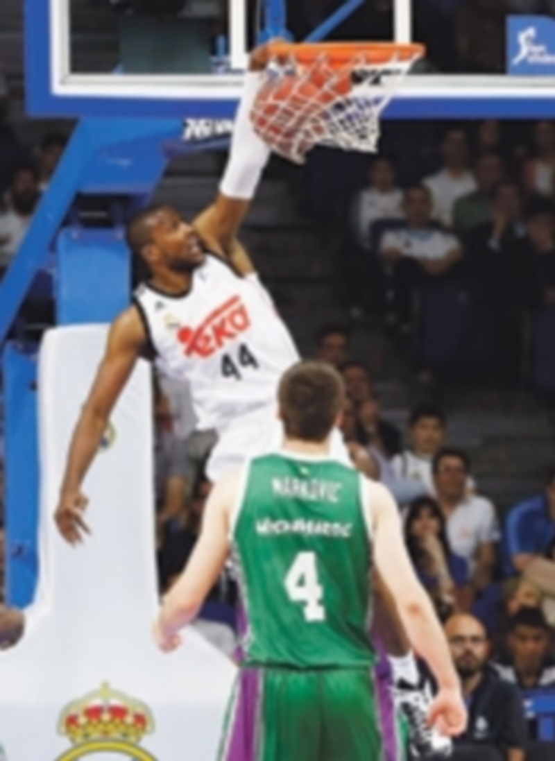 El madridista Marcus Slaughter realiza un mate en el partido ante el Unicaja. / EFE