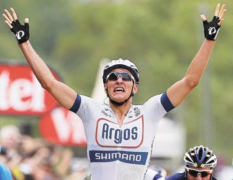 El corredor del equipo Argos Shimano levanta los brazos en señal de victoria. / Efe