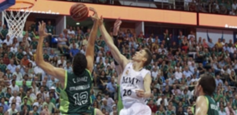 Carlos Suárez (Unicaja) intenta impedir la entrada a canasta de Jaycee Carroll (Real Madrid)./ Efe