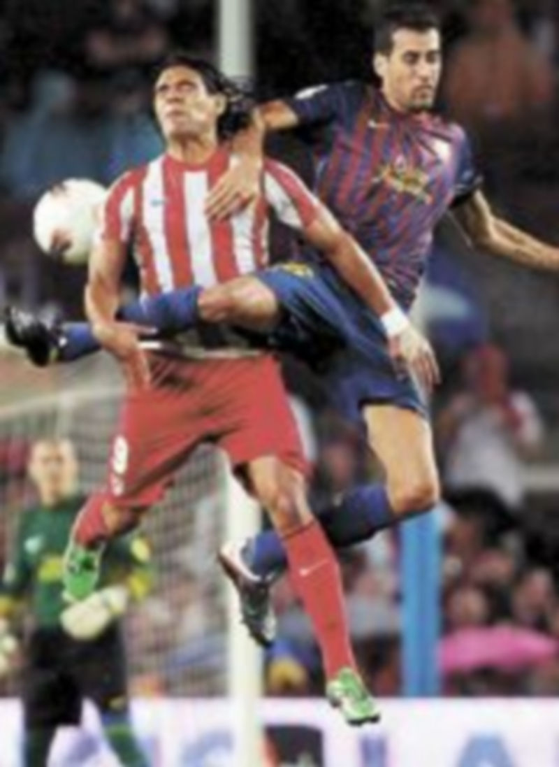 Busquets y Falcao luchan por el balón. / Alberto Estévez (Efe)