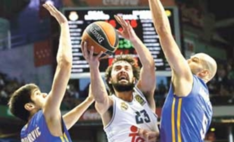 El escolta madridista Sergio Llull (c) entra a canasta ante la defensa de James Augustine (d) y Marko Todorovic. / EFE
