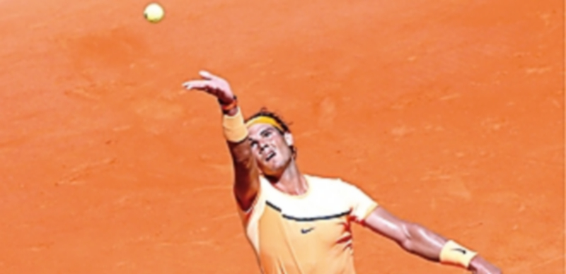 El tenista español Rafa Nadal realiza un saque ante el austríaco Thiem. / EFE