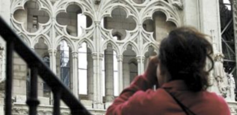 Una turista extranjera recoge con el objetivo de su cámara una imagen a su paso por una ciudad española. / Tomás Alonso