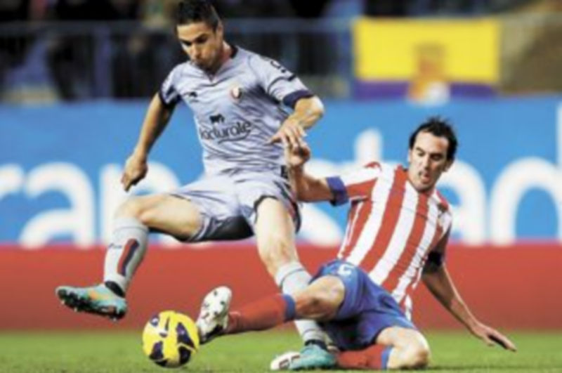 Godín intenta arrebatar el cuero a Kike Sola. / S. Pérez (Reuters)