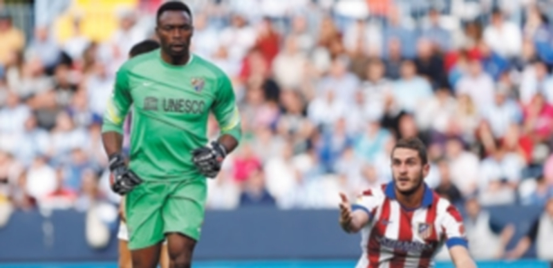 Koke (d) se queja tras una ocasión de pase a sus compañeros ante el portero camerunés del Málaga Carlos Kameni. / EFE