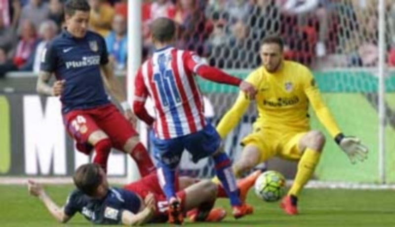 Giménez (izq) y Saúl tratan de frenar al sportinguista Lora ante la presencia del guardameta rojiblanco Oblak. / EFE