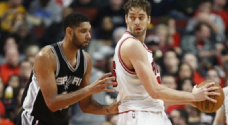 Gasol protege el balón ante la defensa de Duncan